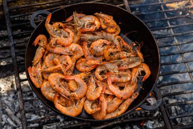 Vahşi doğada kızartma tavasında pişmiş taze karides. Taze yiyeceklerle doğada dinlen.