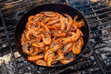 Vahşi doğada kızartma tavasında pişmiş taze karides. Taze yiyeceklerle doğada dinlen.