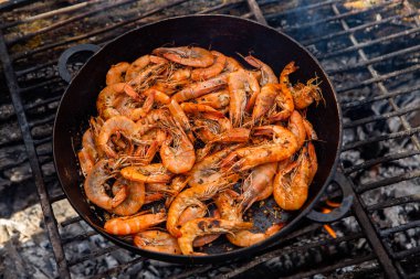 Vahşi doğada kızartma tavasında pişmiş taze karides. Taze yiyeceklerle doğada dinlen.