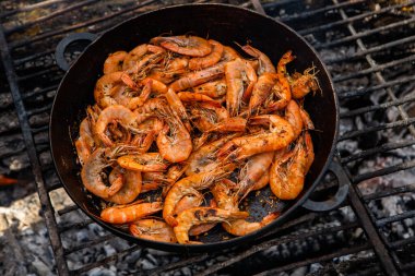 Vahşi doğada kızartma tavasında pişmiş taze karides. Taze yiyeceklerle doğada dinlen.