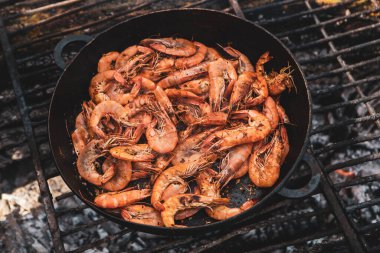 Vahşi doğada kızartma tavasında pişmiş taze karides. Taze yiyeceklerle doğada dinlen.