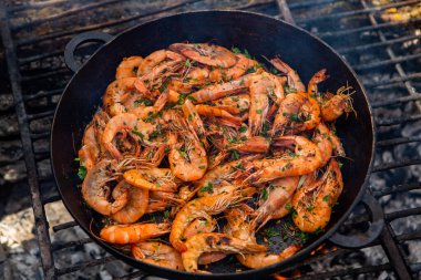 Vahşi doğada kızartma tavasında pişmiş taze karides. Taze yiyeceklerle doğada dinlen.