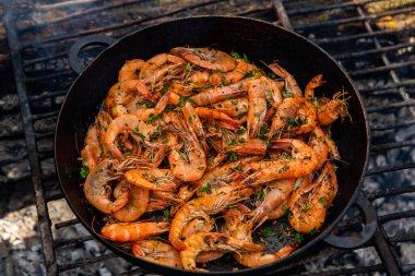 Vahşi doğada kızartma tavasında pişmiş taze karides. Taze yiyeceklerle doğada dinlen.