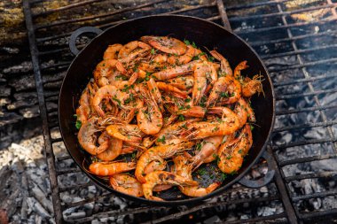 Vahşi doğada kızartma tavasında pişmiş taze karides. Taze yiyeceklerle doğada dinlen.