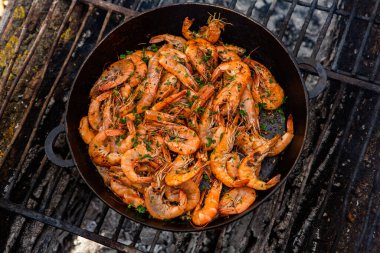 Vahşi doğada kızartma tavasında pişmiş taze karides. Taze yiyeceklerle doğada dinlen.