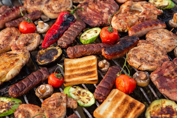 外の火の上に焼き肉の大規模な様々な 肉とピクニック ソーセージ ポークステーキ 野菜と鶏の胸肉 — ストック写真