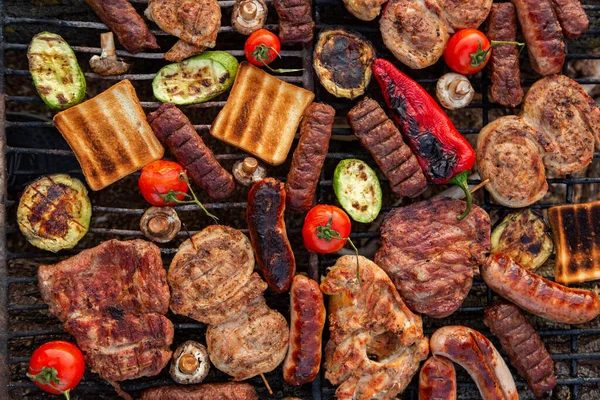 外の火の上に焼き肉の大規模な様々な 肉とピクニック ソーセージ ポークステーキ 野菜と鶏の胸肉 — ストック写真