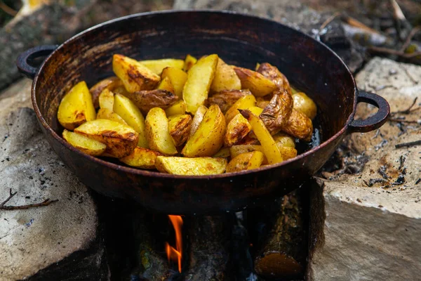 Dışarıda ateşte kızartma tavasında ev yapımı çıtır patates. Doğada piknik yapmak ve yemek yapmak..