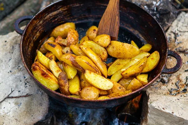 Dışarıda ateşte kızartma tavasında ev yapımı çıtır patates. Doğada piknik yapmak ve yemek yapmak..