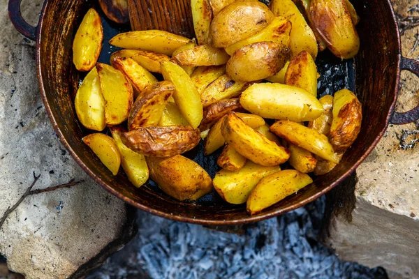 Dışarıda ateşte kızartma tavasında ev yapımı çıtır patates. Doğada piknik yapmak ve yemek yapmak..