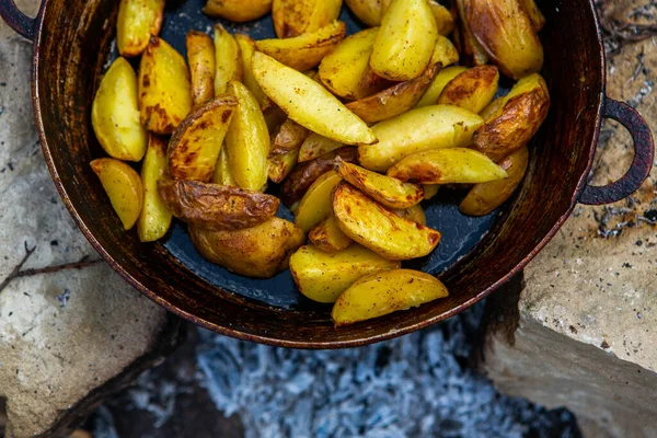Dışarıda ateşte kızartma tavasında ev yapımı çıtır patates. Doğada piknik yapmak ve yemek yapmak..