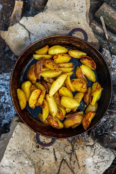 Dışarıda ateşte kızartma tavasında ev yapımı çıtır patates. Doğada piknik yapmak ve yemek yapmak..