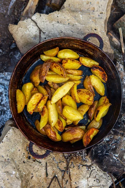 Dışarıda ateşte kızartma tavasında ev yapımı çıtır patates. Doğada piknik yapmak ve yemek yapmak..