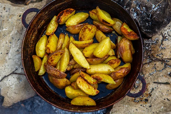 Dışarıda ateşte kızartma tavasında ev yapımı çıtır patates. Doğada piknik yapmak ve yemek yapmak..