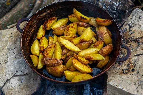 Dışarıda ateşte kızartma tavasında ev yapımı çıtır patates. Doğada piknik yapmak ve yemek yapmak..