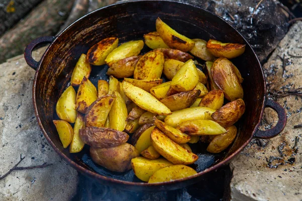 Dışarıda ateşte kızartma tavasında ev yapımı çıtır patates. Doğada piknik yapmak ve yemek yapmak..