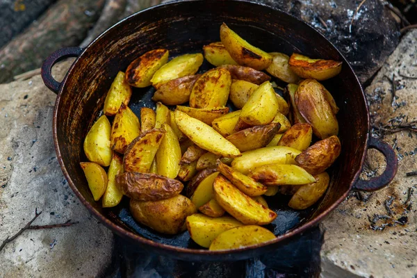 Dışarıda ateşte kızartma tavasında ev yapımı çıtır patates. Doğada piknik yapmak ve yemek yapmak..