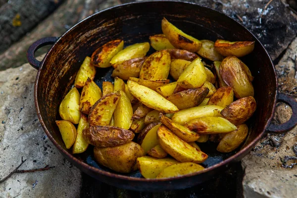 Dışarıda ateşte kızartma tavasında ev yapımı çıtır patates. Doğada piknik yapmak ve yemek yapmak..