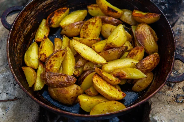Dışarıda ateşte kızartma tavasında ev yapımı çıtır patates. Doğada piknik yapmak ve yemek yapmak..