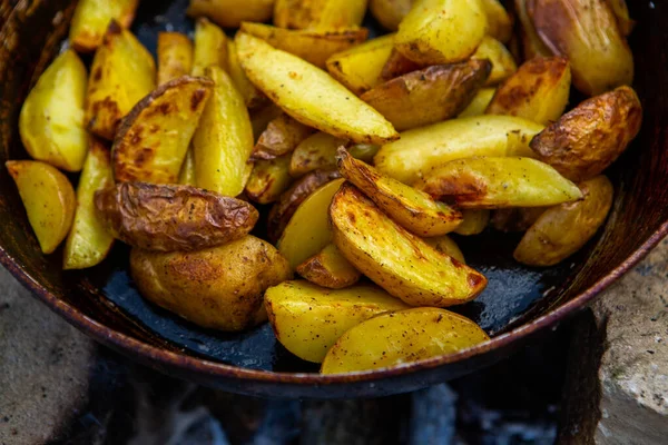 Dışarıda ateşte kızartma tavasında ev yapımı çıtır patates. Doğada piknik yapmak ve yemek yapmak..