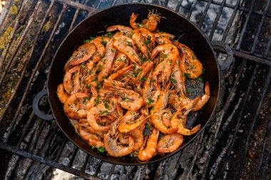 Vahşi doğada kızartma tavasında pişmiş taze karides. Taze yiyeceklerle doğada dinlen.