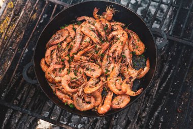 Vahşi doğada kızartma tavasında pişmiş taze karides. Taze yiyeceklerle doğada dinlen.