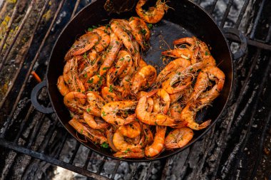 Vahşi doğada kızartma tavasında pişmiş taze karides. Taze yiyeceklerle doğada dinlen.