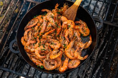 Vahşi doğada kızartma tavasında pişmiş taze karides. Taze yiyeceklerle doğada dinlen.
