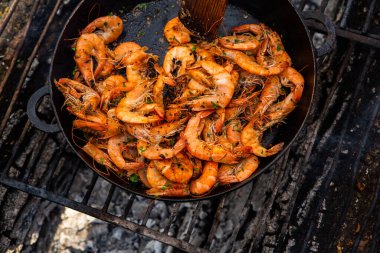 Vahşi doğada kızartma tavasında pişmiş taze karides. Taze yiyeceklerle doğada dinlen.