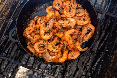 Vahşi doğada kızartma tavasında pişmiş taze karides. Taze yiyeceklerle doğada dinlen.