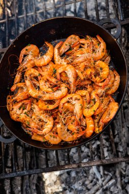 Vahşi doğada kızartma tavasında pişmiş taze karides. Taze yiyeceklerle doğada dinlen.