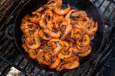 Vahşi doğada kızartma tavasında pişmiş taze karides. Taze yiyeceklerle doğada dinlen.