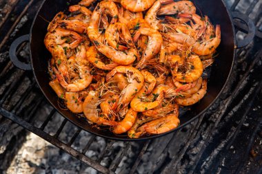 Vahşi doğada kızartma tavasında pişmiş taze karides. Taze yiyeceklerle doğada dinlen.