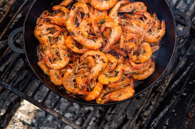 Vahşi doğada kızartma tavasında pişmiş taze karides. Taze yiyeceklerle doğada dinlen.