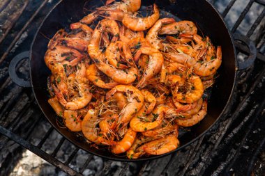Vahşi doğada kızartma tavasında pişmiş taze karides. Taze yiyeceklerle doğada dinlen.
