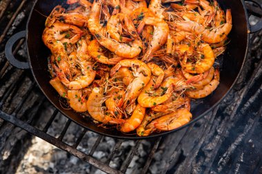 Vahşi doğada kızartma tavasında pişmiş taze karides. Taze yiyeceklerle doğada dinlen.