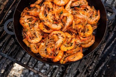 Vahşi doğada kızartma tavasında pişmiş taze karides. Taze yiyeceklerle doğada dinlen.