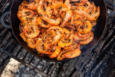Vahşi doğada kızartma tavasında pişmiş taze karides. Taze yiyeceklerle doğada dinlen.
