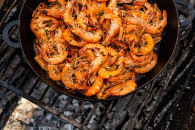 Vahşi doğada kızartma tavasında pişmiş taze karides. Taze yiyeceklerle doğada dinlen.