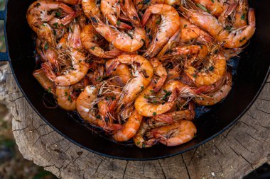 Vahşi doğada kızartma tavasında pişmiş taze karides. Taze yiyeceklerle doğada dinlen.