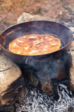 Romen geleneksel peynirli turtası dışarıdaki ateşte tavada pişiyor. Romanya ve Moldova Cumhuriyeti 'nden gıda.