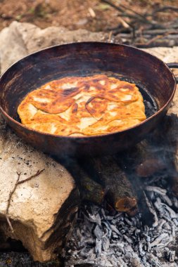 Romen geleneksel peynirli turtası dışarıdaki ateşte tavada pişiyor. Romanya ve Moldova Cumhuriyeti 'nden gıda.