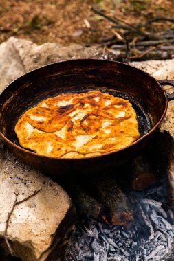 Romen geleneksel peynirli turtası dışarıdaki ateşte tavada pişiyor. Romanya ve Moldova Cumhuriyeti 'nden gıda.