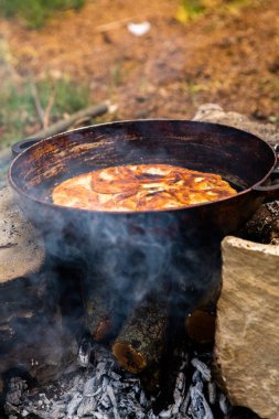 Romen geleneksel peynirli turtası dışarıdaki ateşte tavada pişiyor. Romanya ve Moldova Cumhuriyeti 'nden gıda.