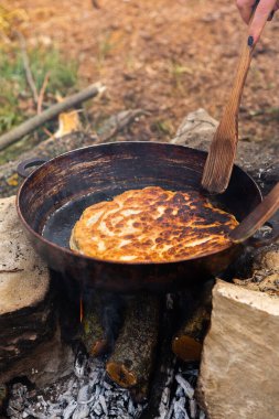 Romen geleneksel peynirli turtası dışarıdaki ateşte tavada pişiyor. Romanya ve Moldova Cumhuriyeti 'nden gıda.