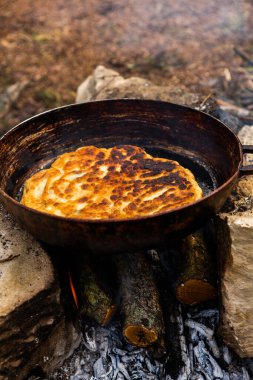 Romen geleneksel peynirli turtası dışarıdaki ateşte tavada pişiyor. Romanya ve Moldova Cumhuriyeti 'nden gıda.