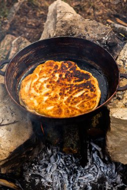 Romen geleneksel peynirli turtası dışarıdaki ateşte tavada pişiyor. Romanya ve Moldova Cumhuriyeti 'nden gıda.