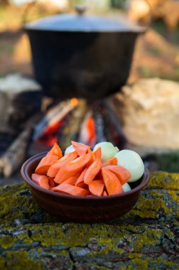 Açık ateşte hazırlanmış balık çorbası. Çaydanlıkta açık ateşte balık çorbası pişirmek. Turizm ve balıkçılıkta yemek pişirmek
