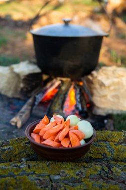Açık ateşte hazırlanmış balık çorbası. Çaydanlıkta açık ateşte balık çorbası pişirmek. Turizm ve balıkçılıkta yemek pişirmek