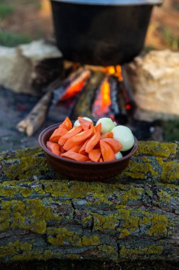 Açık ateşte hazırlanmış balık çorbası. Çaydanlıkta açık ateşte balık çorbası pişirmek. Turizm ve balıkçılıkta yemek pişirmek